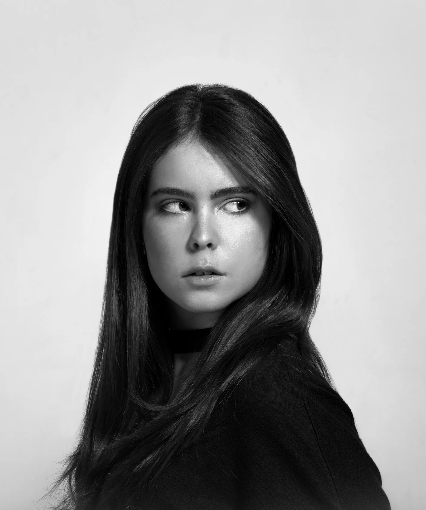 Black and white portrait of a woman with straight dark hair, looking to her right with serious expression.