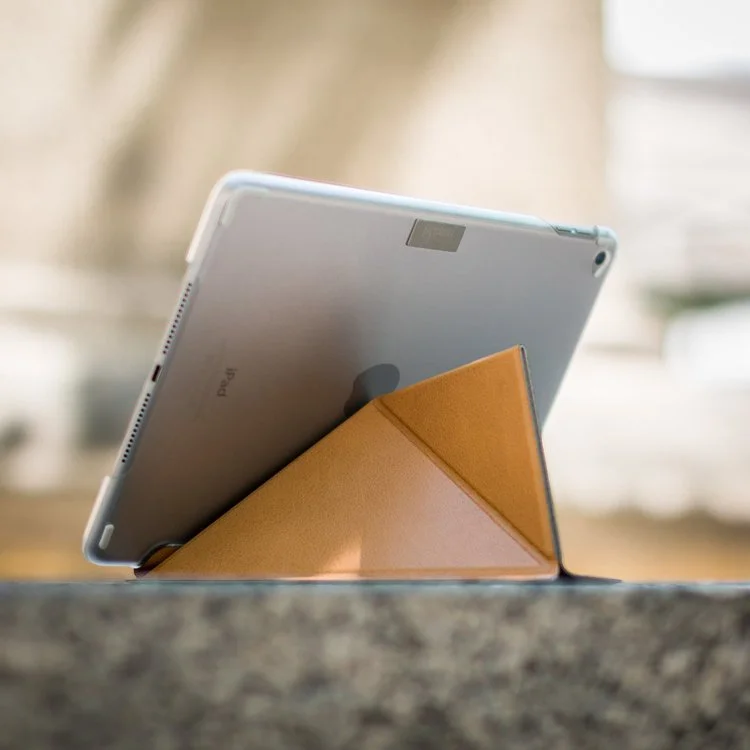 A tablet with a brown leather foldable cover resting on a textured surface.