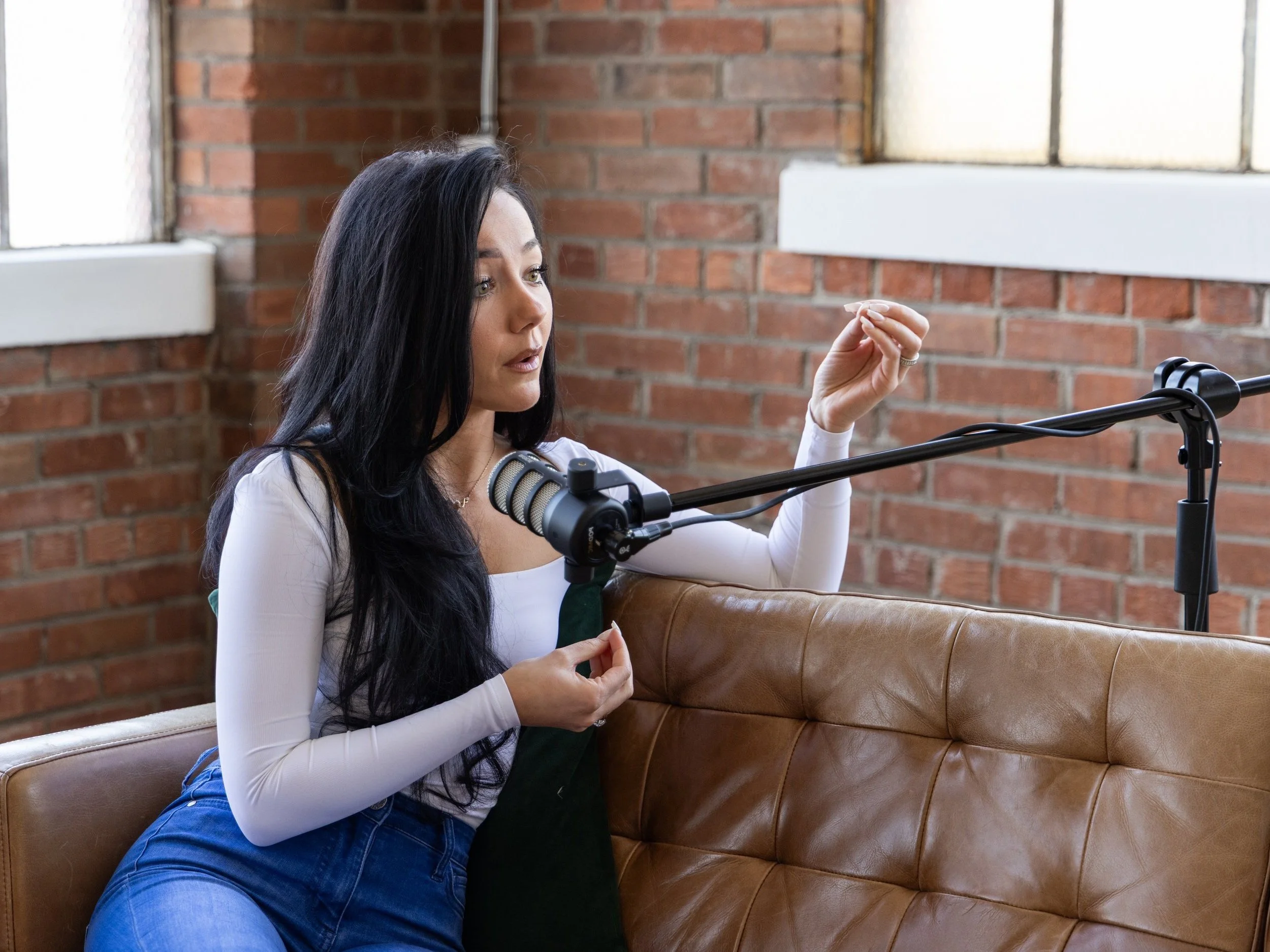 Rebecca recording in the 115creative studio with a podcast microphone.